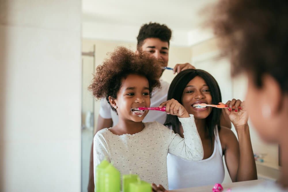 parents with child, brushing teeth
